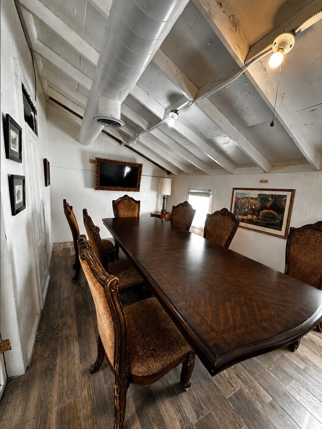 The Elsinore Boardroom, a long executive table ringed by high backed chairs beneath a mounted TV