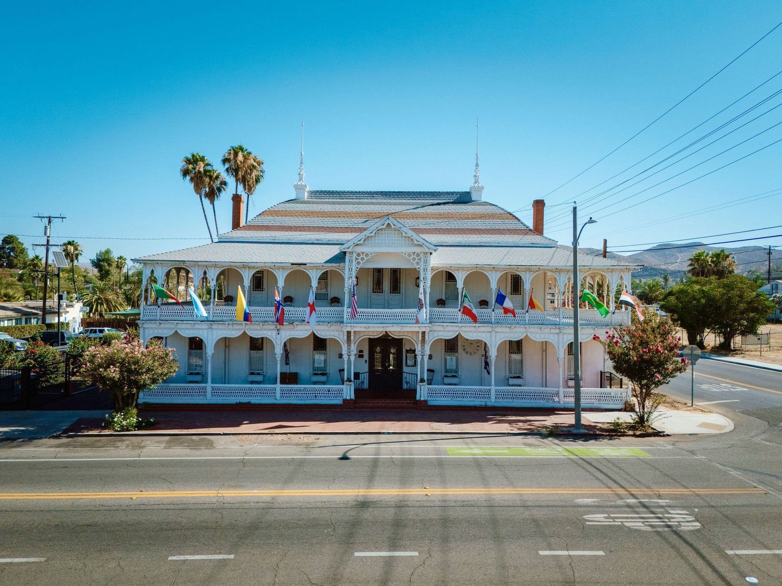 The Crescent House 1887 seen from the street, its double verandas hung with international flags