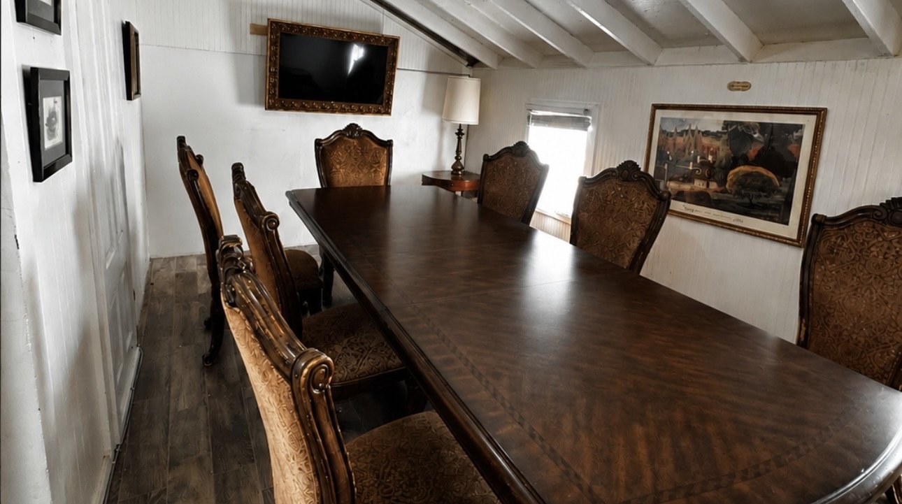 A restored upstairs meeting room at The Crescent House with a long wood table and period furnishings