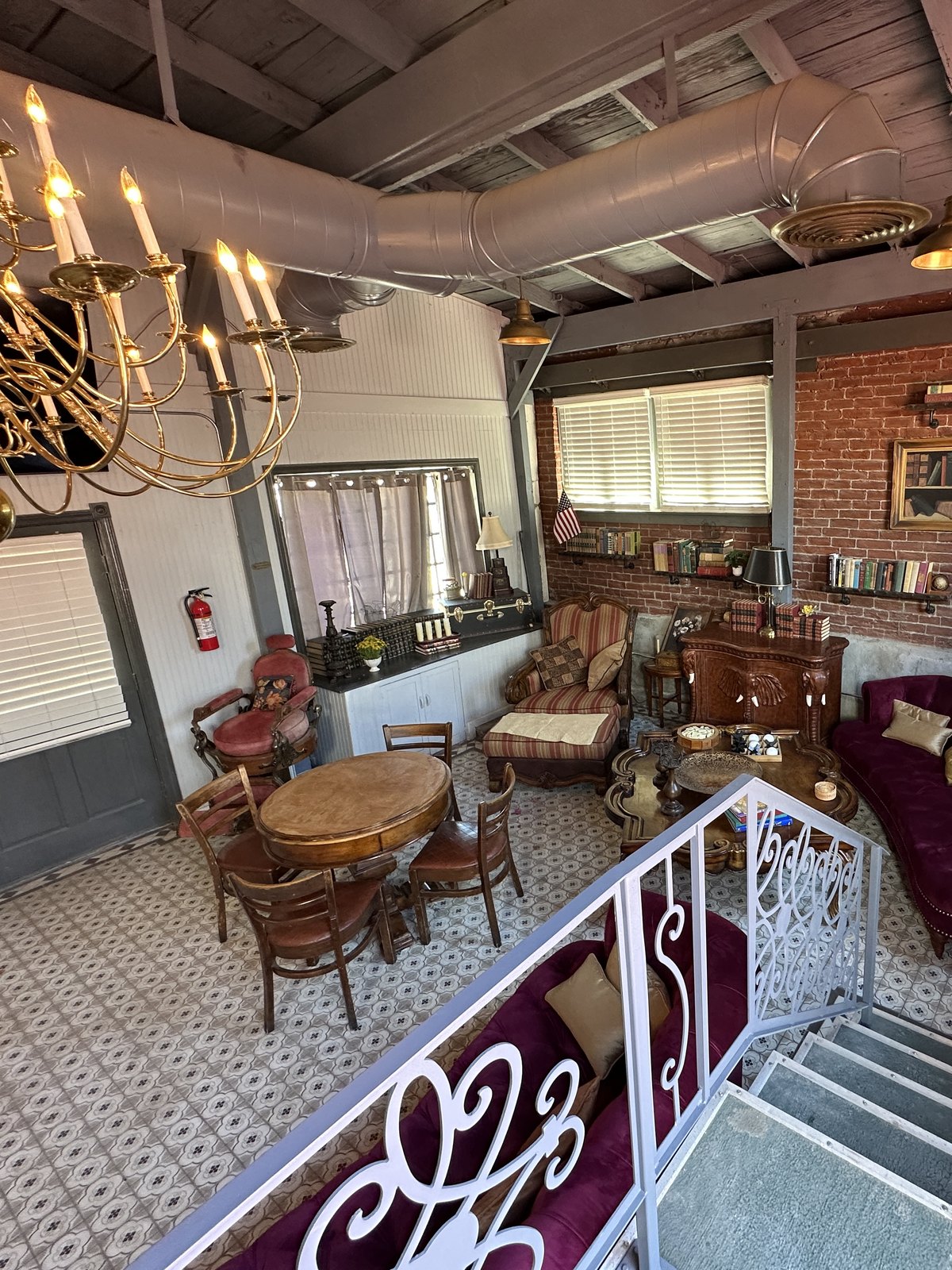 The Library Speakeasy, with its brick wall of books, gold chandelier, and velvet seating on patterned tile